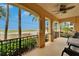 Inviting porch with decorative columns and a view of the ocean and palm trees at 6412 Mayra Shores Ln, Apollo Beach, FL 33572