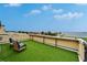Roof deck with artificial grass, lounge seating and views of palm trees and bay at 6412 Mayra Shores Ln, Apollo Beach, FL 33572