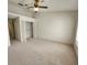 Spacious bedroom with neutral carpet, ceiling fan, and a large closet with double doors at 6620 121St Ave # 1, Largo, FL 33773