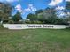 A deed restricted Pinebrook Estates community sign on a grassy hill at 6620 121St Ave # 1, Largo, FL 33773