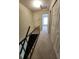 Hallway featuring carpet, access to bedrooms, and staircase with black handrail at 6620 121St Ave # 1, Largo, FL 33773