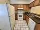 Well-equipped kitchen with white appliances, tile floors, and wood cabinets at 6620 121St Ave # 1, Largo, FL 33773