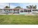 Exterior view of a charming home with a well-manicured lawn and lush landscaping at 800 Chesapeake Dr # 23, Tarpon Springs, FL 34689