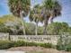 Stone sign for Fred H. Howard Park featuring mature palm trees and lush greenery at 800 Chesapeake Dr # 23, Tarpon Springs, FL 34689