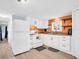 Bright kitchen featuring white cabinets, modern appliances, and an eye-catching orange accent wall at 800 Chesapeake Dr # 23, Tarpon Springs, FL 34689