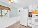 Bright kitchen featuring white appliances, beadboard walls, ample cabinet space, and natural light from the window at 800 Chesapeake Dr # 23, Tarpon Springs, FL 34689