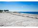 Wide sandy beach with scattered beachgoers and calm blue ocean waters under a clear sky at 800 Chesapeake Dr # 23, Tarpon Springs, FL 34689