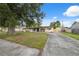 Street view of a white brick house with covered parking and a long concrete driveway at 8256 Lark St, Seminole, FL 33777