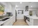Well-lit kitchen with stainless steel appliances, white cabinets, stone countertops, and backyard access at 8256 Lark St, Seminole, FL 33777