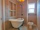 Charming bathroom featuring a clawfoot tub, neutral tiling, and decorative lighting at 8759 Orient Ne Way, St Petersburg, FL 33702