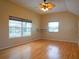 Inviting bedroom featuring hardwood floors, a ceiling fan, and large windows offering ample natural light at 8759 Orient Ne Way, St Petersburg, FL 33702