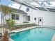 Inviting backyard oasis featuring a sparkling pool with a screened enclosure and lush tropical landscaping at 8759 Orient Ne Way, St Petersburg, FL 33702