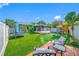 Wide backyard shot with trampoline, playset, shed, grassy area, and patio at 12351 Cloverstone Dr, Tampa, FL 33624