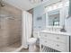 Bright bathroom featuring a walk-in shower with tiled walls and a white vanity with marble countertops at 12351 Cloverstone Dr, Tampa, FL 33624