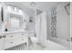 Well-lit bathroom with a tub, a toilet and single vanity with modern fixtures at 12351 Cloverstone Dr, Tampa, FL 33624