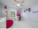 Bright bedroom showcasing tiled floors, a ceiling fan, and cute colorful decor at 12351 Cloverstone Dr, Tampa, FL 33624