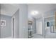 Hallway featuring updated lighting and a view to a room with a TV at 12351 Cloverstone Dr, Tampa, FL 33624