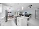 Open concept kitchen with white cabinets, island with seating, and adjacent living room with backyard access at 12351 Cloverstone Dr, Tampa, FL 33624