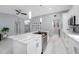 Bright kitchen boasts white cabinets, marble countertops, stainless steel appliances and modern lighting at 12351 Cloverstone Dr, Tampa, FL 33624