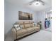 Bright living room with a beige couch and stylish red washer and dryer in the background at 12351 Cloverstone Dr, Tampa, FL 33624