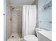 Bright shower featuring tiled walls with a glass shower curtain and modern showerhead at 12351 Cloverstone Dr, Tampa, FL 33624