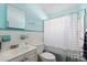 Clean bathroom featuring white fixtures, tiled walls, and a shower with a curtain at 1453 Belleair Rd, Clearwater, FL 33756