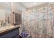 Well-lit bathroom featuring a vanity, toilet, and themed shower curtain at 1453 Belleair Rd, Clearwater, FL 33756