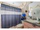 Functional bathroom with a shower, toilet, sink, and striped shower curtain, designed for everyday use at 1453 Belleair Rd, Clearwater, FL 33756