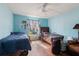 Bright bedroom featuring wood floors, ceiling fan, and natural light streaming through the window at 1453 Belleair Rd, Clearwater, FL 33756
