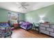 Cozy bedroom with wood laminate flooring, a ceiling fan, and a window with natural light at 1453 Belleair Rd, Clearwater, FL 33756