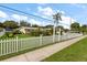 Lovely home with a white picket fence, green lawn, landscaping, and clear blue skies at 1453 Belleair Rd, Clearwater, FL 33756