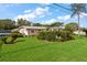 Single-story home with a landscaped yard featuring neatly trimmed hedges and a white picket fence at 1453 Belleair Rd, Clearwater, FL 33756