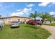Exterior view of a house with well-kept lawn, palm trees, and multiple parked cars at 1453 Belleair Rd, Clearwater, FL 33756