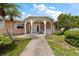 Charming home entrance featuring a decorative white portico, walkway, and a well-maintained lawn at 1453 Belleair Rd, Clearwater, FL 33756