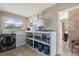 Laundry area featuring a washer and dryer, storage shelves, and natural light from a window at 1453 Belleair Rd, Clearwater, FL 33756