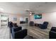 Bright living room featuring tile and wood flooring, comfortable seating, and a large television at 1453 Belleair Rd, Clearwater, FL 33756