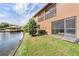 Back exterior of home facing canal, with covered patio and landscaping and AC units at 14625 Par Club Cir # 14625, Tampa, FL 33618