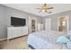 Comfortable bedroom with hardwood floors, a ceiling fan, and an ensuite bathroom at 18164 Turning Leaf Cir, Land O Lakes, FL 34638
