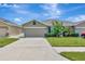 Charming one-story home with a well-manicured lawn, lush landscaping, and a wide driveway at 18164 Turning Leaf Cir, Land O Lakes, FL 34638