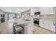 Modern kitchen featuring white cabinets, stainless steel appliances, and a spacious granite countertop island at 18164 Turning Leaf Cir, Land O Lakes, FL 34638