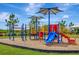 Community playground featuring colorful play structures, slides and sunshades on a mulch base at 18164 Turning Leaf Cir, Land O Lakes, FL 34638