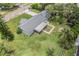 An aerial view shows this home with a gray roof, screened in porch, and generous, tree-filled yard at 2612 Lenna Ave, Seffner, FL 33584
