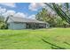 Expansive backyard with lush green grass, garden beds, patio, and mature trees, perfect for outdoor enjoyment at 2612 Lenna Ave, Seffner, FL 33584
