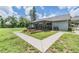 Backyard featuring a well-maintained lawn, garden beds, a patio, and lush greenery, creating a private oasis at 2612 Lenna Ave, Seffner, FL 33584
