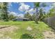 View of a spacious backyard showcasing lush greenery, tall trees, and a well-maintained lawn at 2612 Lenna Ave, Seffner, FL 33584