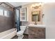 Bathroom featuring gray tiling, a wooden vanity, toilet, shower with curtain, and decorative light fixture at 2612 Lenna Ave, Seffner, FL 33584