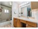 Bathroom featuring double sinks, wooden vanity, and combination bathtub and shower at 2612 Lenna Ave, Seffner, FL 33584