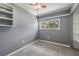 This bedroom features neutral carpeting, grey paint, a ceiling fan, a built-in shelf, and a window at 2612 Lenna Ave, Seffner, FL 33584