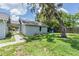 Exterior view of the home's side and backyard, showcasing the mature trees and a garden area at 2612 Lenna Ave, Seffner, FL 33584