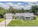 A front view of a light blue house with a covered porch, stone accents, and an attached garage at 2612 Lenna Ave, Seffner, FL 33584